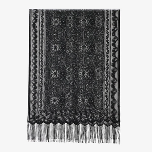 Dettaglio del motivo floreale in pizzo nero con eleganti frange decorative