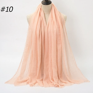Close-up of light peach long scarf with pleated texture and fringe hem detail