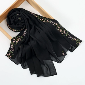 Close-up of black chiffon scarf featuring delicate pink floral embroidery and leaf details
