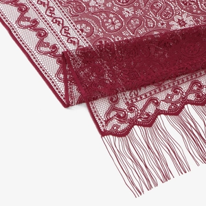 Dettaglio di scialle in pizzo bordeaux con motivi paisley e lunghe frange raffinate