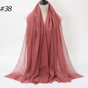 Detail shot of dusty rose pearl bubble hijab scarf with natural texture and frayed edges