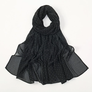 Detail of black chiffon scarf featuring delicate white rhinestones and a light texture
