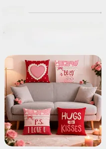 Detail von roten und rosa Valentinstags-Kissen mit Herzmotiven auf grauem Sofa