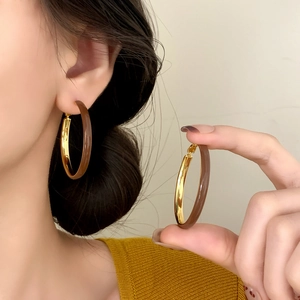 Elegant large hoop earrings with gold metal and dark brown acrylic contrast design