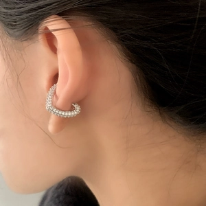 Elegant silver heart ear cuff with micro-paved zircons shown on a female model