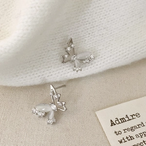 Elegant silver butterfly stud earrings with zircon and cat eye stone on textured fabric