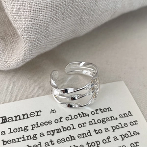 Macro detail of silver triple-layered twisted geometric ring with polished finish