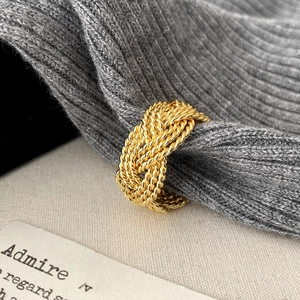 Detail of twisted multi-strand golden ring with woven design and textured finish
