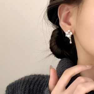 Elegant French-style pearl and zircon drop earrings worn by a model in a side view