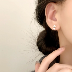 Elegant tulip flower pearl stud earrings in silver finish worn by a model