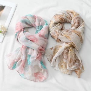 Detail of floral voile scarves showing soft rose patterns in pink and coffee tones