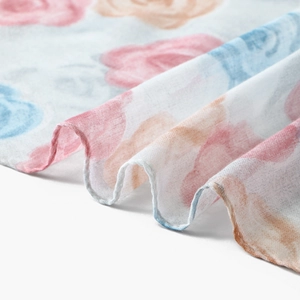 Detailed view of floral printed voile scarf showing soft pink rose patterns and sheer fabric
