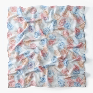 Close-up of translucent voile scarf with watercolor floral print and soft fabric folds