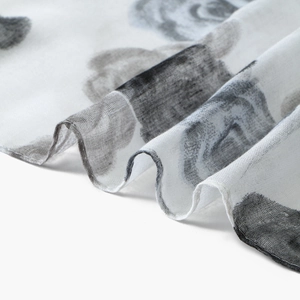 Close-up of lightweight voile scarf fabric showing detailed black floral ink print