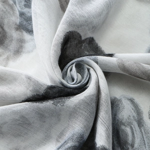 Macro detail of breathable voile fabric featuring ink-style floral print patterns