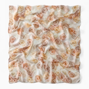 Detail of a sheer voile scarf featuring elegant warm-toned floral patterns and smooth edges