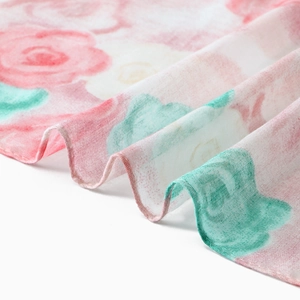 Macro detail of floral voile scarf featuring pink roses and fine mesh texture weaving