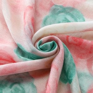 Detail of floral voile scarf fabric showing soft pink and turquoise watercolor texture