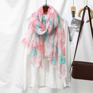 Detail of floral voile scarf with pink and blue roses draped on a white shirt