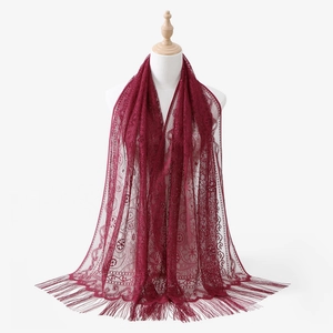 Dettaglio sciarpa in pizzo bordeaux con motivi floreali traforati e lunghe nappe