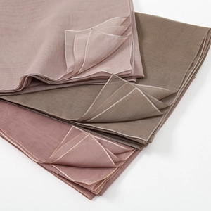 Detail of mercerized cotton scarves in pink and taupe showing soft texture and stitching
