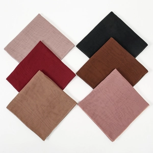 Detail of six multicolored mercerized cotton scarves with fine pleated texture on white background