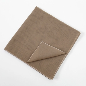 Detail of mercerized cotton scarf showing brown fabric texture and fine white edge stitching