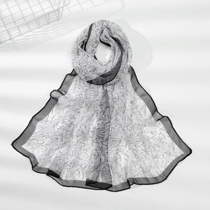 Dettaglio sciarpa leggera in chiffon floreale bianco e nero con bordo rifinito nero