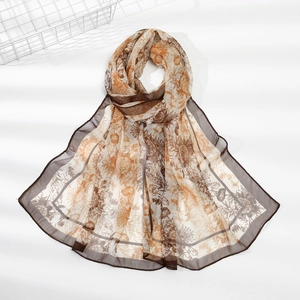 Detail of a vintage floral chiffon scarf with brown earth tones and delicate hem edges
