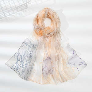Dettaglio di una sciarpa in chiffon traslucido con stampa floreale e ombre eleganti