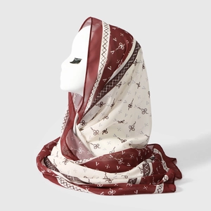 Detail of burgundy floral chiffon hijab with bow patterns draped on a model head