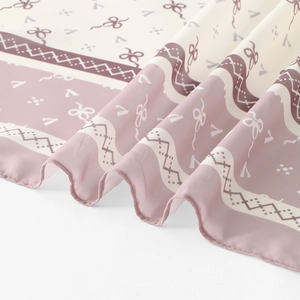 Detail of printed chiffon headscarf with elegant bow patterns and soft silk texture