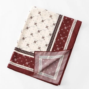 Detailed texture of elegant chiffon scarf featuring wine red bow patterns and silk sheen