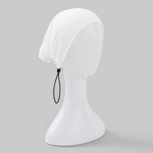 Détail du turban extensible blanc avec cordon de serrage noir ajustable et boucle de serrage
