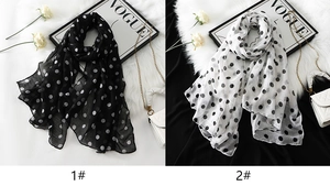 Close-up of lightweight polka dot chiffon scarves in black and white styles