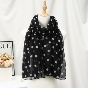 Lightweight black voile scarf with white polka dots draped on a fashion mannequin