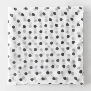 Detailed view of lightweight white voile fabric featuring classic black polka dot pattern