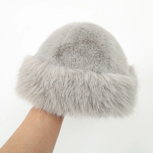 Close-up of fluffy grey faux fur winter hat featuring soft texture and black fabric lining