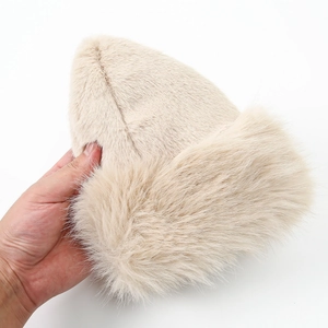 Close-up of thick beige faux fur winter hat showing plush texture and fluffy fibers