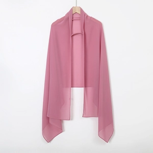 Detail of a pink lightweight chiffon shawl hanging on a wooden hanger for a stylish look