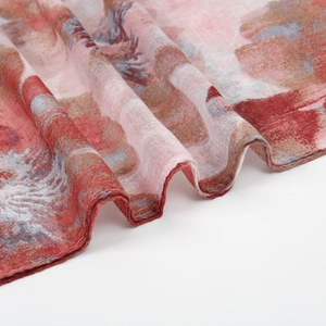 Close-up of lightweight floral voile scarf showing red and blue ink-style print and fine stitching