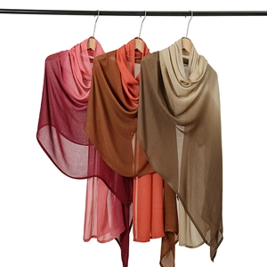 Detail of three gradient modal scarves in magenta, caramel and coffee brown tones