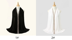 Detail showing white and black soft headscarves with sparkling sequin V-neck trim