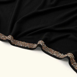 Detail of scalloped edge on black headscarf with gold and silver rhinestone embellishment