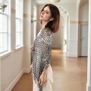 Close-up of silver sequin mesh shawl featuring delicate tassel fringe and metallic texture