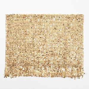 Macro detail of golden sequins and matching fringe tassels on a luxury evening shawl