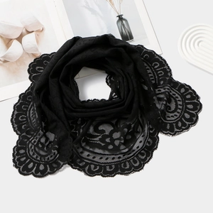 Detail of black floral lace scarf featuring intricate openwork crochet and scalloped edges