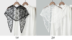 Détail d'écharpes en dentelle brodée florale noire et blanche sur des cols de chemise