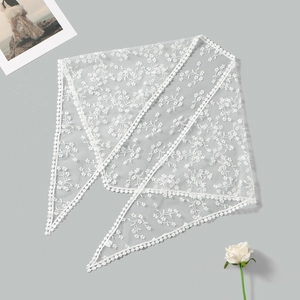 Gros plan détaillé de la broderie en dentelle florale blanche et des bords au crochet du foulard