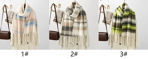 Detailed view of three plaid cashmere-feel scarves with soft fringe in various colors